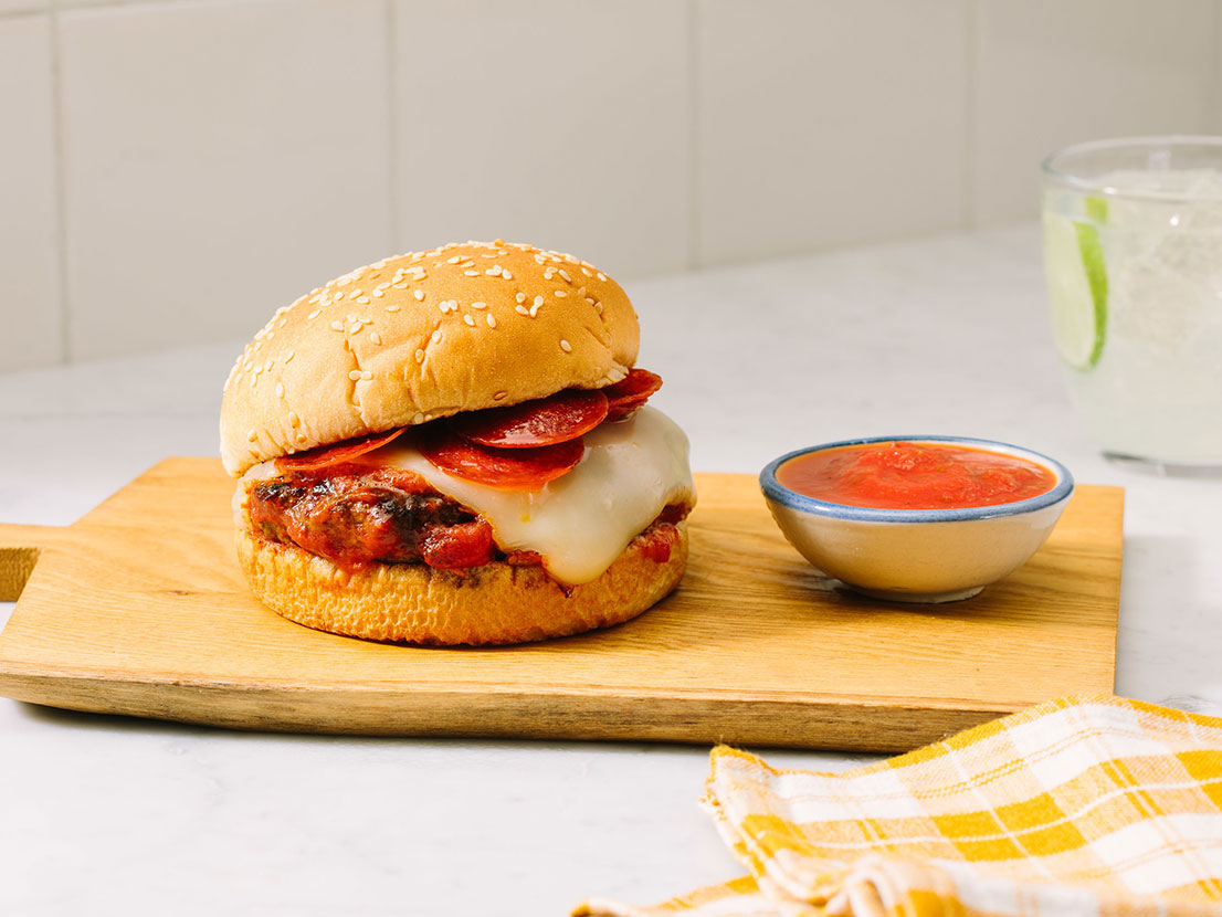 An image of prepared Easy Skillet Pizza Burgers made with Prego® Traditional Italian Sauce, ground beef, Parmesan, mozzarella, pepperoni and Pepperidge Farm® Farmhouse Hearty White Buns.