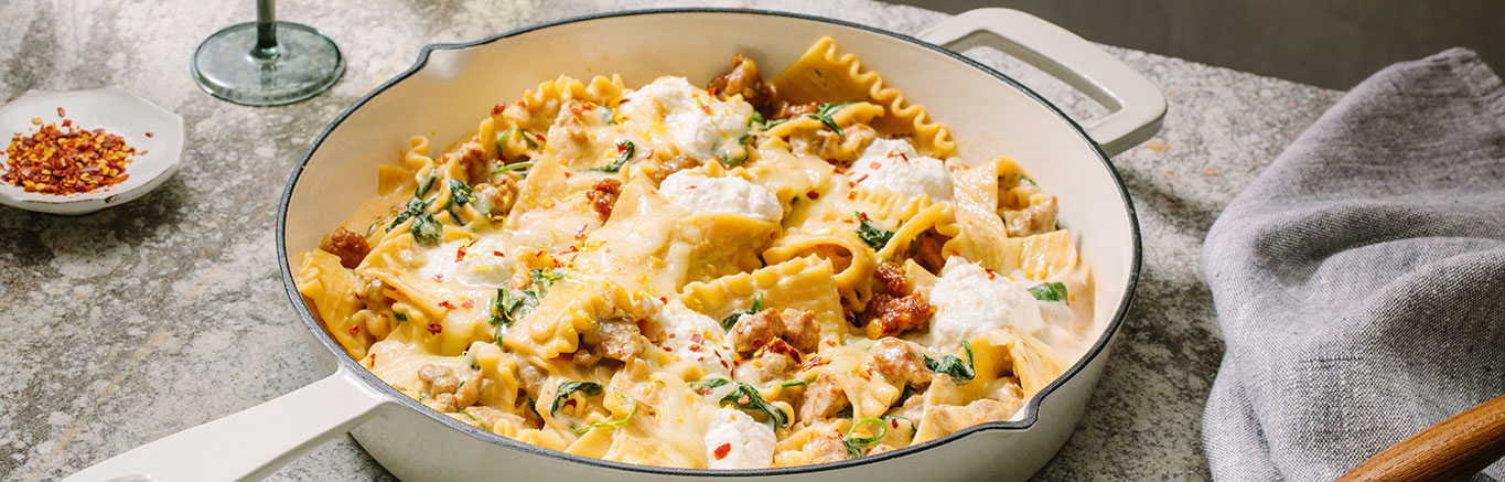 An image of prepared One Pot White Lasagna made with Prego® Homestyle Alfredo Sauce, Italian sausage, onion, lasagna noodles, baby spinach, mozzarella and ricotta cheese.