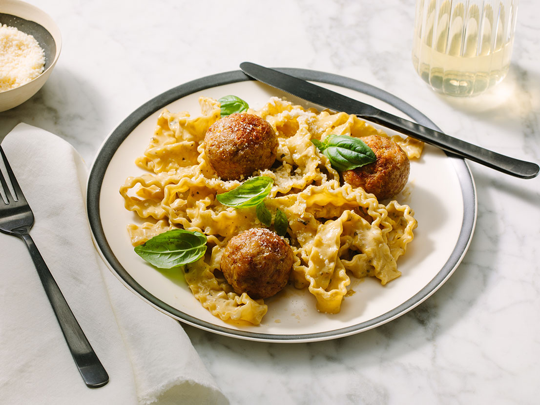 An image of prepared Creamy Pesto Turkey Meatballs made with with Prego® Creamy Roasted Garlic Pesto Sauce, ground turkey and Parmesan cheese.