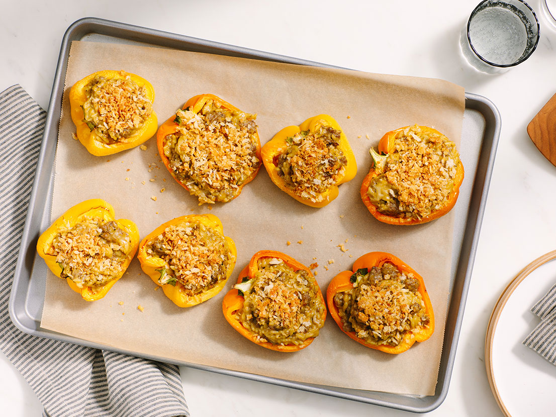 An image of prepared Easy Pesto Stuffed Peppers made with orzo, bell peppers, chicken sausage, Prego® Creamy Basil Pesto Sauce and mozzarella.