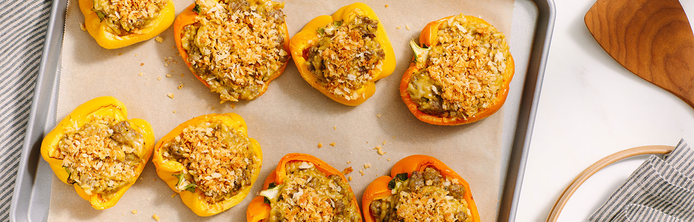 An image of prepared Easy Pesto Stuffed Peppers made with orzo, bell peppers, chicken sausage, Prego® Creamy Basil Pesto Sauce and mozzarella.