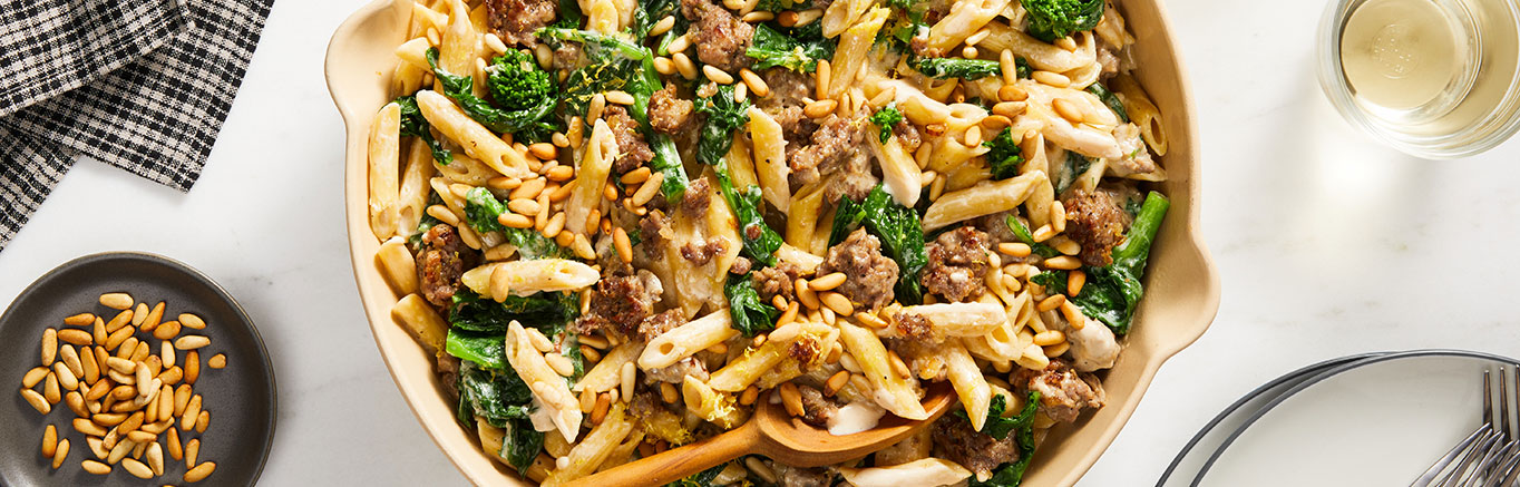 An image of prepared One Pot Sausage & Broccoli Rabe Pasta made with pork sausage, broccoli rabe, Prego® Garlic & Caramelized Onion Alfredo Sauce, Swanson® Natural Goodness® Chicken Broth and penne pasta.